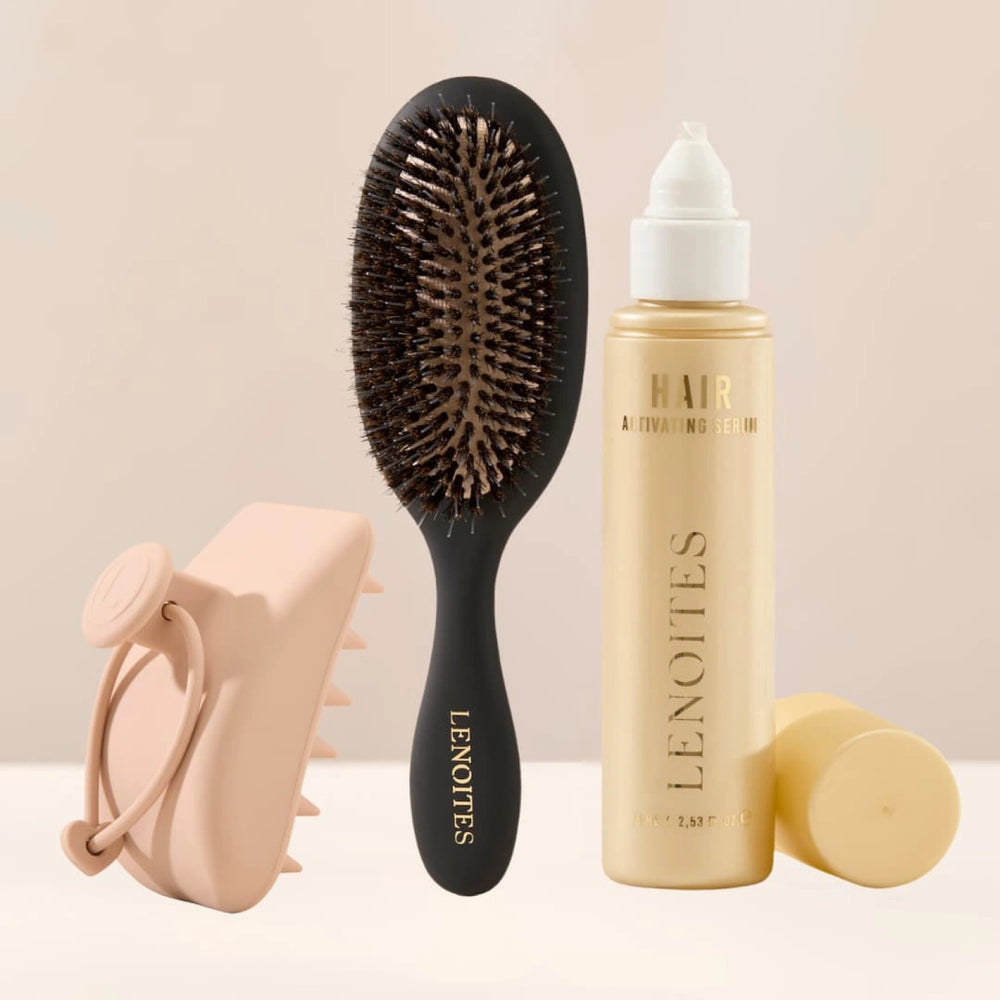 The Complete Hair Kit by Lenoites featuring a black hairbrush, a Hair Scalp Massager and the Hair Growth Serum in a transparent bottle with a golden tone, styled against a soft light beige background.