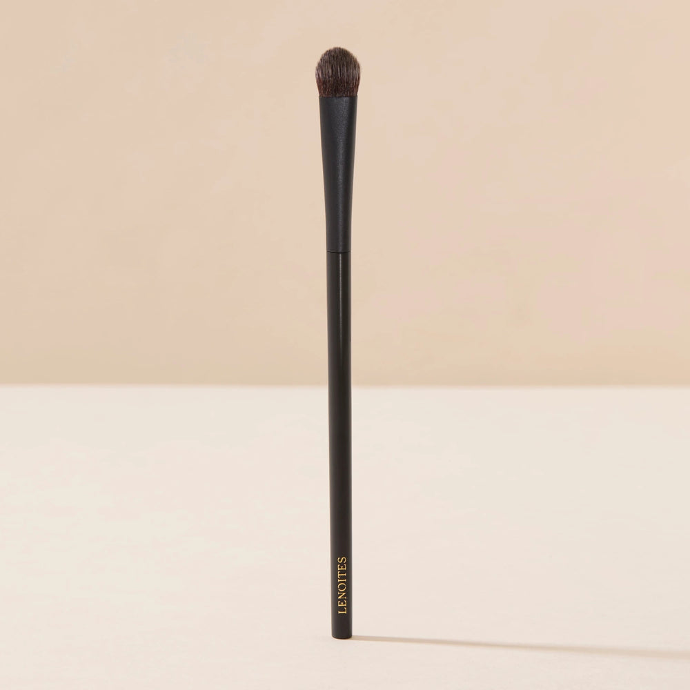 Brush Me Blending Multi Eye Brush No. 134 by Lenoites, featuring a sleek black handle with a soft, rounded brush head, displayed against a soft beige background.