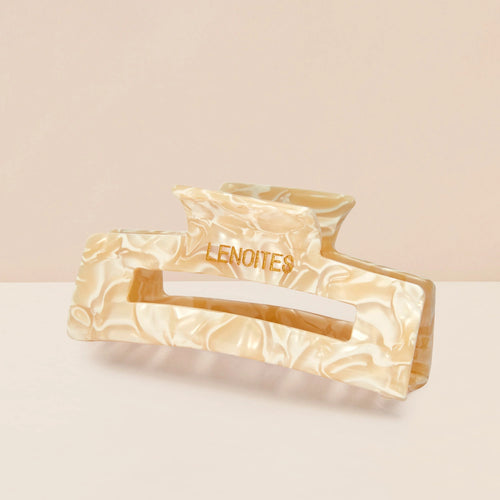 Eco-friendly Hair Claw Medium in Champagne Pearl by Lenoites, featuring the brand logo in gold, displayed against a soft beige background.