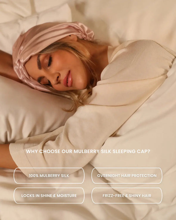 Woman sleeping wearing a pink Lenoites Mulberry Silk Sleeping Cap on white bedding. It protects hair, adds shine, and prevents frizz.