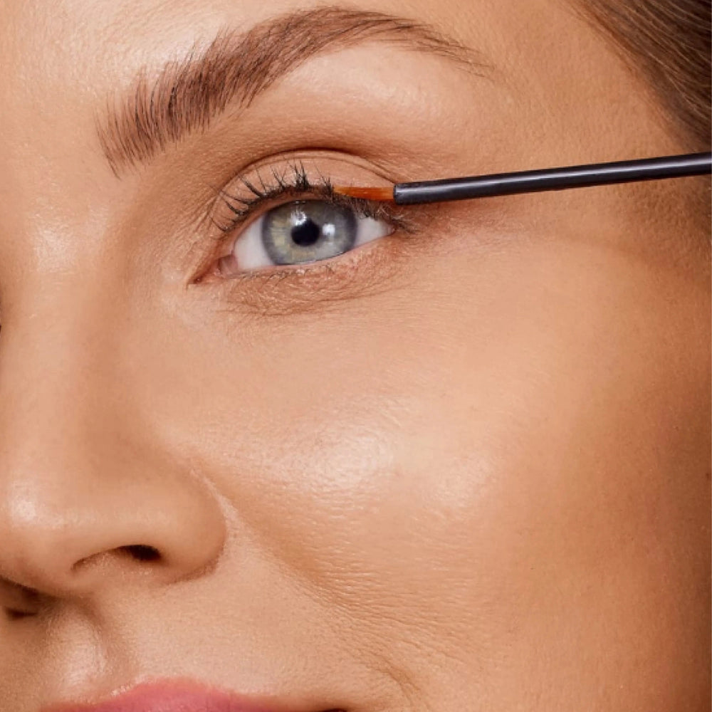 Lash Growth Serum + Eyebrow Growth Serum Set by Lenoites featuring a soft rosegold tube for the lash serum and a gold tube for the eyebrow serum, both with their applicators visible, displayed on a soft beige background.