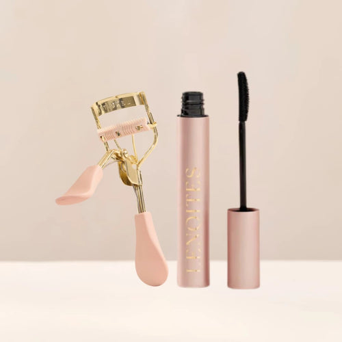 Love at First Lash by Lenoites featuring a pink eyelash curler with gold details and a rosegold PowerLash Growth Serum Mascara tube with a black shade of the mascara, displayed against a soft beige background.