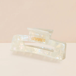 Eco-friendly Hair Claw Medium in Pearly White by Lenoites, featuring the brand logo in gold, displayed against a soft beige background.