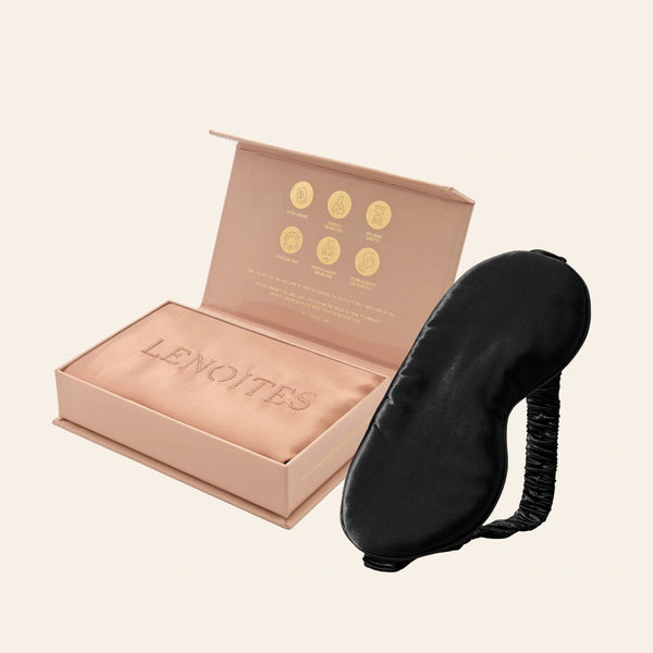 Pillowcase and Sleep Mask in Mulberry Silk by Lenoites featuring a black silk sleep mask and a rosegold mulberry silk pillowcase presented in an open blush pink box against a soft light background.