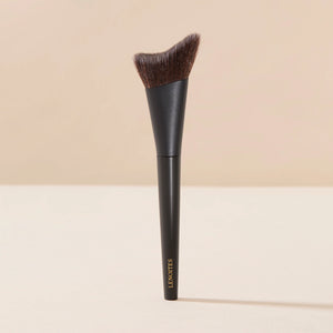 Brush Me Smoothing Foundation Brush No. 101 by Lenoites, featuring a black handle and a soft, angled brush head designed for smooth foundation application, displayed against a soft beige background.