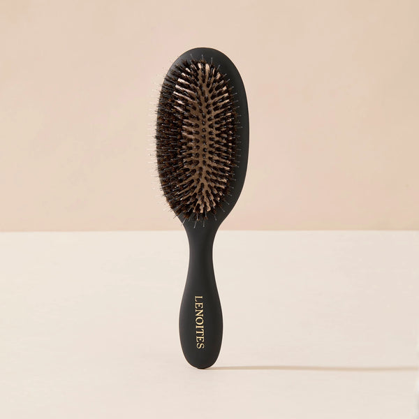 Wild Boar Hair Brush in Black by Lenoites, featuring a sleek handle and bristles, displayed against a soft beige background.
