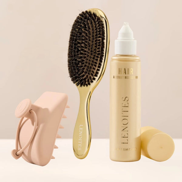 The Complete Hair Kit by Lenoites featuring a gold hairbrush, a Hair Scalp Massager and the Hair Growth Serum in a transparent bottle with a golden tone, styled against a soft light beige background.